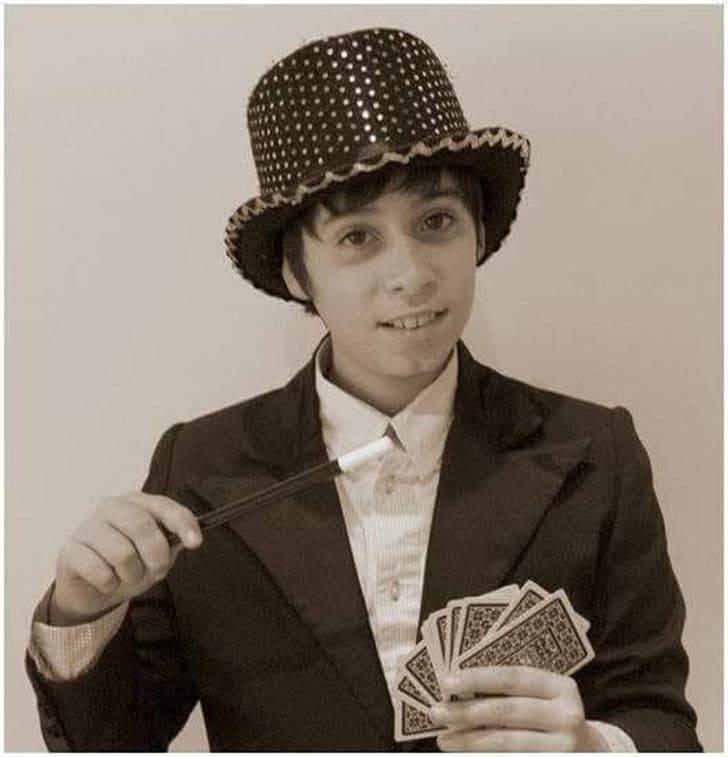 Magic Pol de petit, amb un barret de copa, una vareta i una baralla de cartes