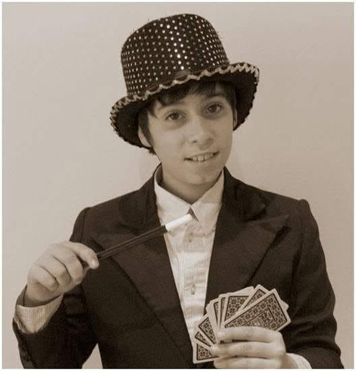 Magic Pol de petit, amb un barret de copa, una vareta i una baralla de cartes